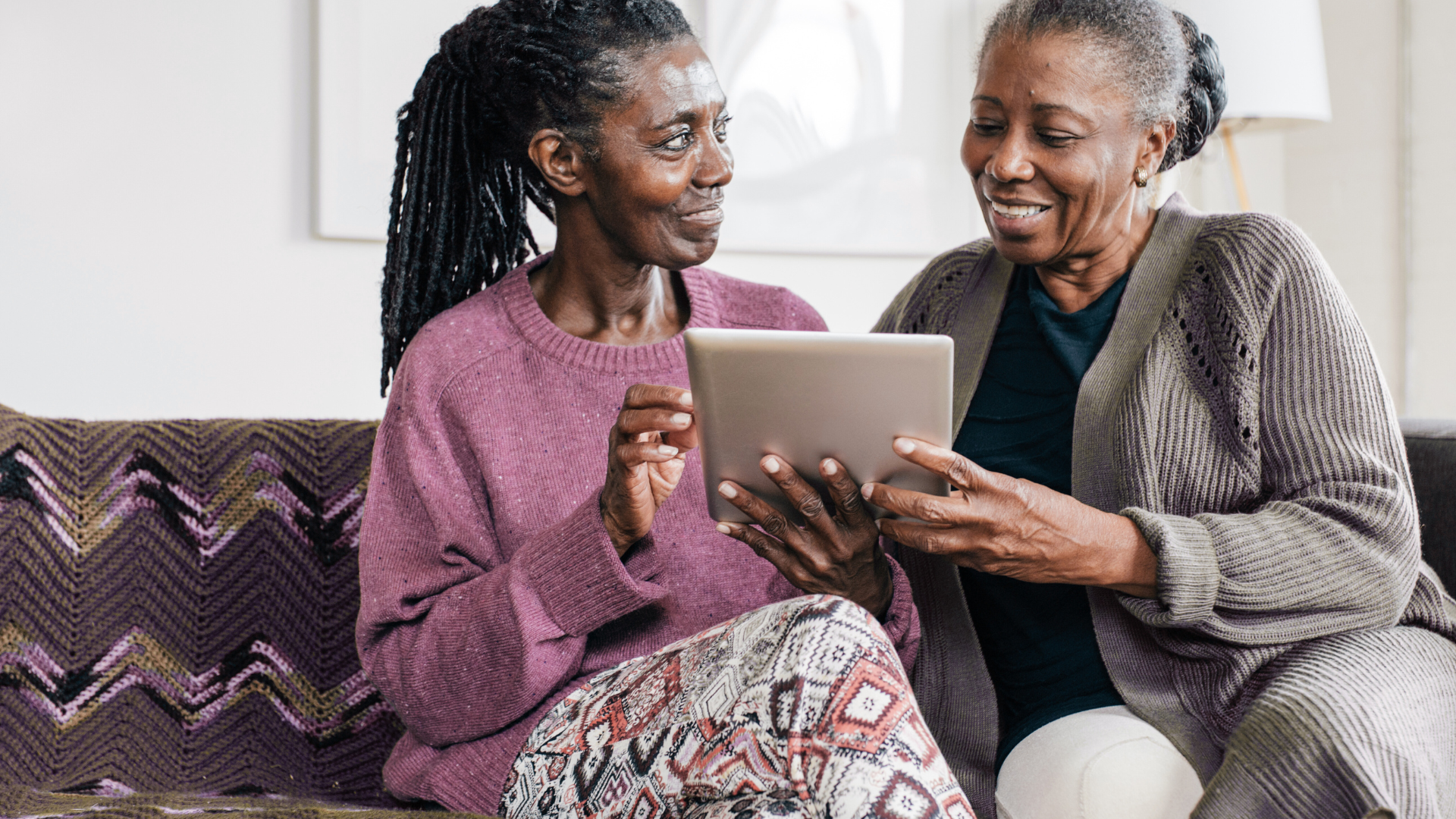 Black seniors looking at tech device
